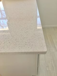 a white counter top sitting on top of a wooden floor