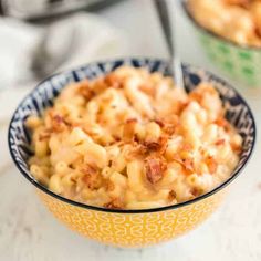 two bowls filled with macaroni and cheese on top of a white countertop