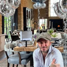 a man sitting at a table with balloons in the background