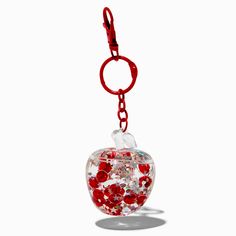 an apple shaped keychain with red and white sequins on the inside