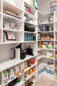 an organized pantry with white shelving and lots of food