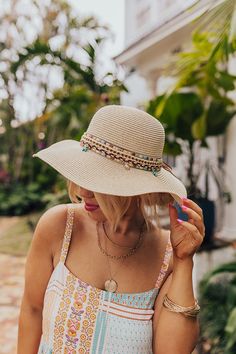 - Live your best beach life with this trendy raffia hat! - Woven material - A woven band featuring browns, peach, and turquoise and a tie detail - Dangling seashell and starfish charms - Hat Dimensions: - Length-16 Inches - Width- 15.5 Inches - Height-4 Inches - Cranial Circumference- 22 Inches - Brim Width- 4 Inches Beige Brimmed Sun Hat For Poolside, Adjustable Beige Straw Hat For Poolside, Lightweight Beige Straw Hat For Pool, Chic Beige Sun Hat For The Beach, Beachy Beige Straw Hat For Beach Season, Bohemian Straw Sun Hat For Travel, Beige Wide Brim Straw Hat For Poolside, Beige Straw Hat For Beach Vacation, Beige Straw Hat For Vacation Beachwear