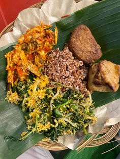 a basket filled with different types of food on top of a leafy green surface