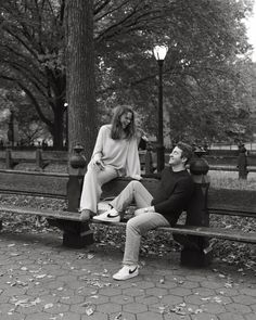 black and white photograph of two people sitting on a park bench