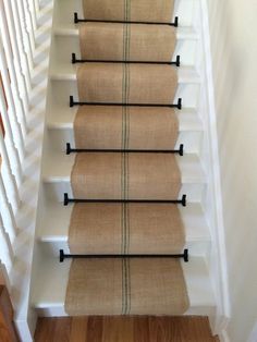 a set of stairs with beige carpet and black railings