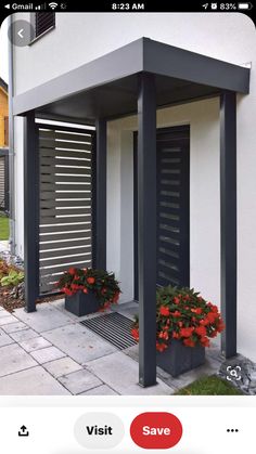 two planters with red flowers are on the side of a house's front porch