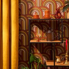 a shelf with vases and other items on it in front of a yellow curtain