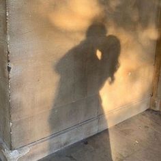 a shadow of a person standing next to a wall with the words real ones make you fall in love with yourself first