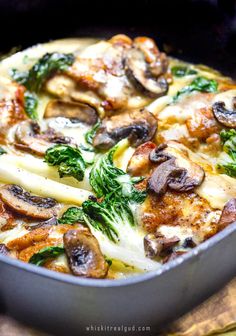 a pan filled with pasta and mushrooms on top of a table