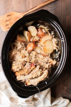 a slow cooker filled with meat and potatoes