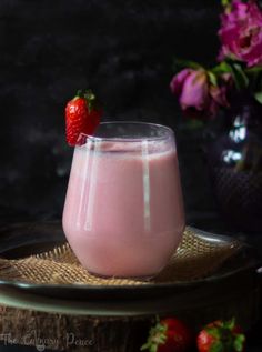 a strawberry milkshake in a glass on a plate