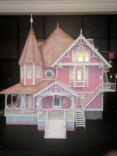 a paper cut out of a pink house with stairs and lights on the front porch