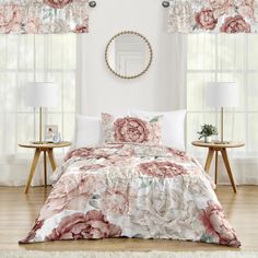 a bed in a bedroom with pink flowers on the comforter and two side tables