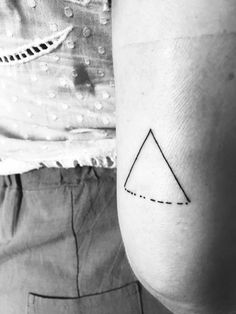 a person with a small triangle tattoo on their arm