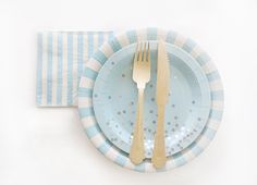 a blue and white plate with silverware on it, next to a striped napkin