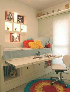 a room with a bed, desk and chair in it next to a rug on the floor