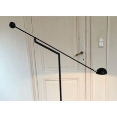 a black floor lamp sitting next to a white door