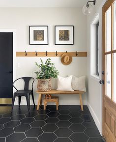 a black and white entryway with two chairs, a bench and a potted plant