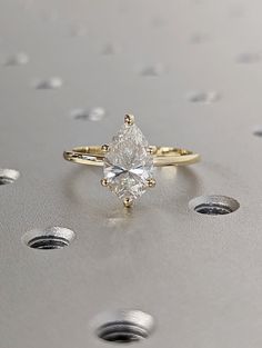 a white diamond ring sitting on top of a table