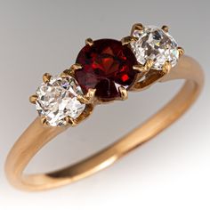 This vintage three-stone ring is centered with one (1) round natural garnet in a six-prong setting. On either side of center is one (1) old European cut diamond in a shared six -prong setting. The ring measures 6.5mm at the top, rises 5.3mm above the finger, tapering to 1.7mm wide and 1.3mm thick at the base of the shank. The ring is currently a size 7.5. The garnet has light abrasions that cannot be seen with the unaided eye. Vintage Garnet Rings, Dimond Ring, Antique Cocktail Ring, Vintage Jewelry Antique, European Cut Diamonds, Three Stone Rings, Three Stone, Stone Ring, High Quality Jewelry