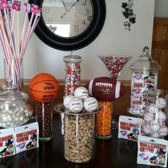 a table topped with lots of candy and candies next to a wall mounted clock