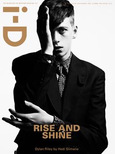 a man in a suit and tie on the cover of gq magazine with his hands up to his face