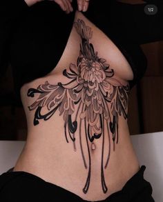 a woman's stomach with an intricate tattoo design on her belly and back side