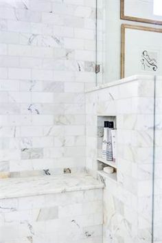 a bathroom with white marble walls and floor