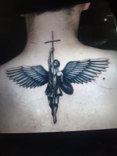 a man with a cross and angel tattoo on his back