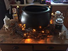 a witches caulder is sitting on a table with candles and other items around it