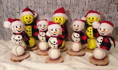 a group of snowmen with hats and scarves on top of wooden bases in front of a stone wall