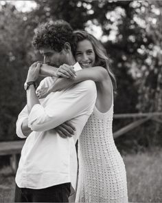 a man and woman hugging each other in black and white