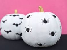 two white pumpkins decorated to look like cats