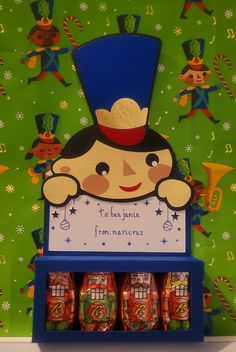 there is a blue shelf with candy in front of green wallpaper and an image of a boy wearing a top hat