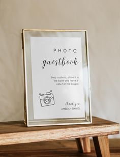 a photo guest book sitting on top of a wooden table next to a white wall