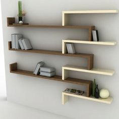 three shelves with books, magazines and other items on them against a white wall in an empty room