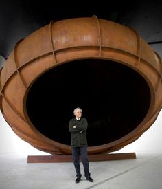 a man standing in front of a large wooden object