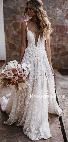 a woman in a wedding dress holding a bouquet and walking down the street with her back to the camera