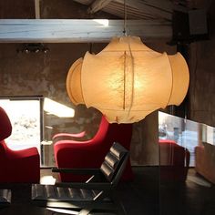 a room with chairs and lamps hanging from the ceiling