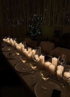 a long table is set with wine glasses and candles