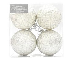 four white ornaments in a clear box on a white background with the package tag underneath it