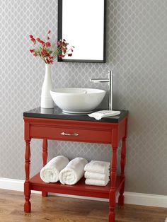 a bathroom with a sink, mirror and towels on the shelf in front of it