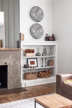 a living room filled with furniture and a fire place next to a wall mounted mirror