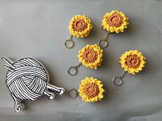 four crocheted sunflowers are shown with a key chain attached to them