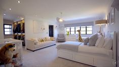 a bedroom with white furniture and giraffe stuffed animal on the bed in it