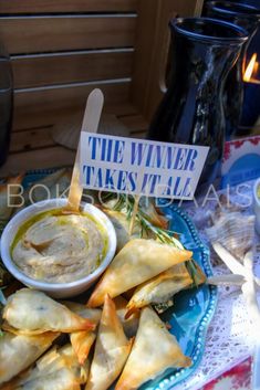 a blue plate topped with wontons and dipping sauce