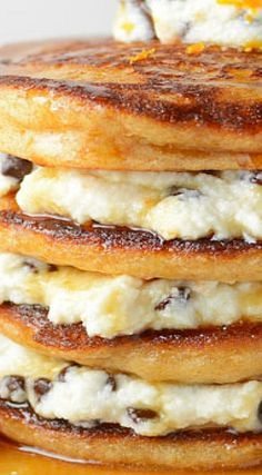 a stack of pancakes with chocolate chips and cream on top are stacked high in the air