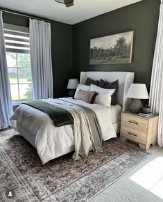 a bedroom with green walls and white curtains