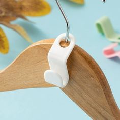 a close up of a pair of scissors hanging from a wooden hanger on a blue background