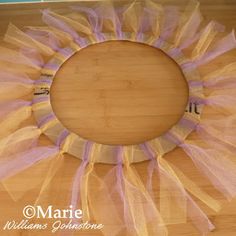 a wreath made out of tulle sitting on top of a wooden table